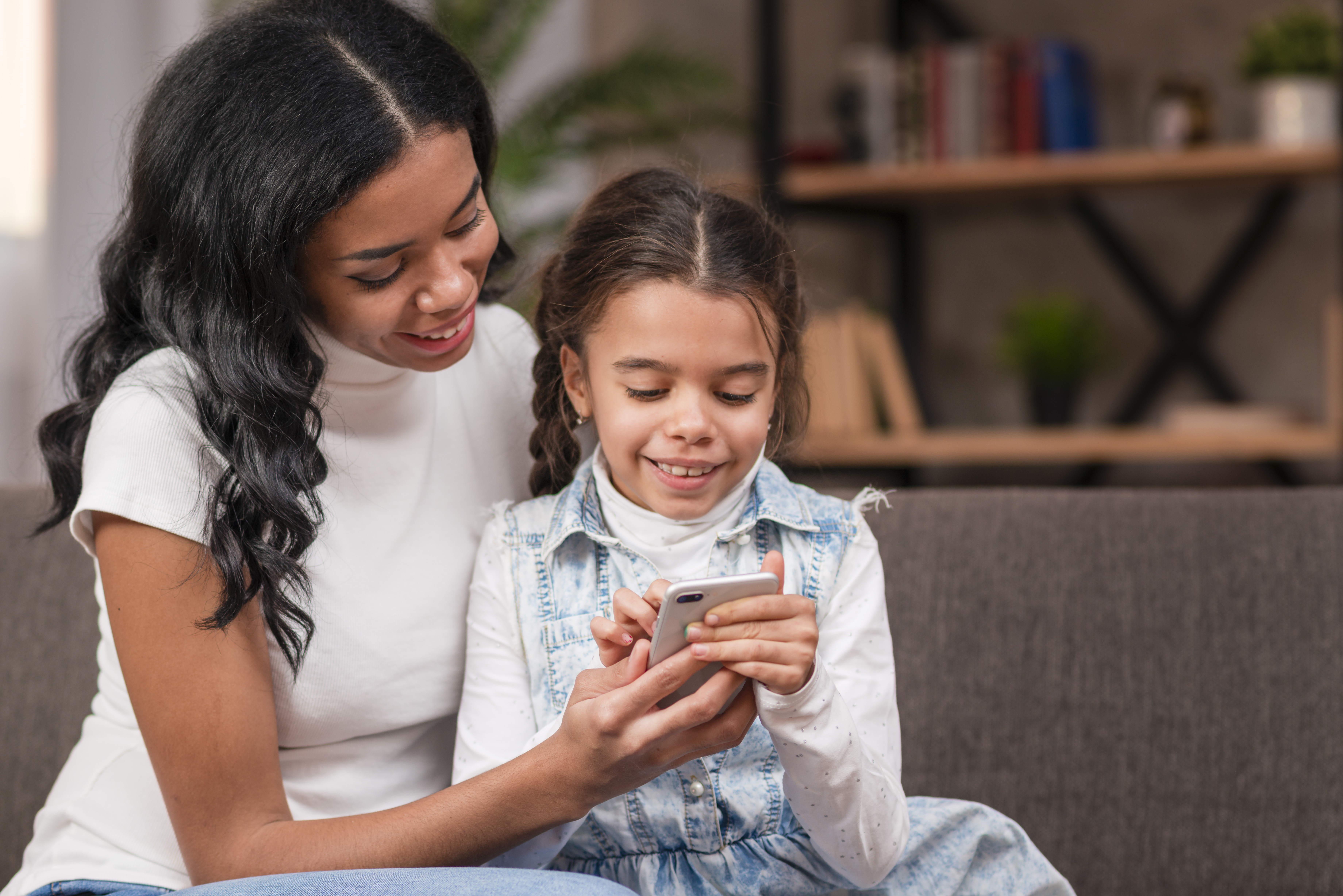 Imagen de niña y señora usando celular
